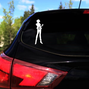 May include: A black car with a white vinyl sticker of a person with a circle on their chest. The sticker is on the rear window of the car.