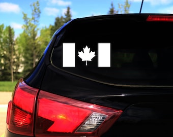 Può includere: Un'auto nera con un adesivo della bandiera canadese bianca sul lunotto posteriore.