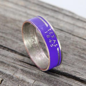May include: A silver ring with a purple band and the words "TEXAS 1845" engraved on the band.