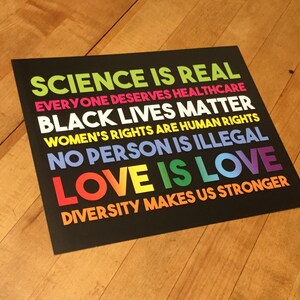 May include: A black and white poster with colourful text that reads "Science is real, Everyone deserves healthcare, Black lives matter, Women's rights are human rights, No person is illegal, Love is love, Diversity makes us stronger."