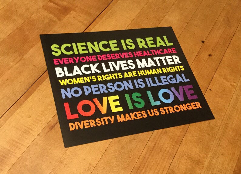 May include: A black and white poster with colourful text that reads "Science is real, Everyone deserves healthcare, Black lives matter, Women's rights are human rights, No person is illegal, Love is love, Diversity makes us stronger."