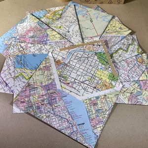 May include: A collection of folded maps with various city and state road maps. The maps are arranged in a starburst pattern with the Chicago map in the center.