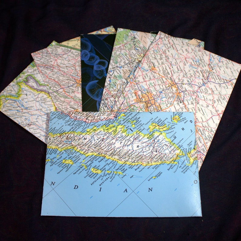 May include: A blue map of the Indonesian island of Mentawai, with the words "Kepulauan Mentawai" and "Nias" printed on the map. The map is surrounded by other maps, including a map of a city with roads and a map with a blue and black abstract design.