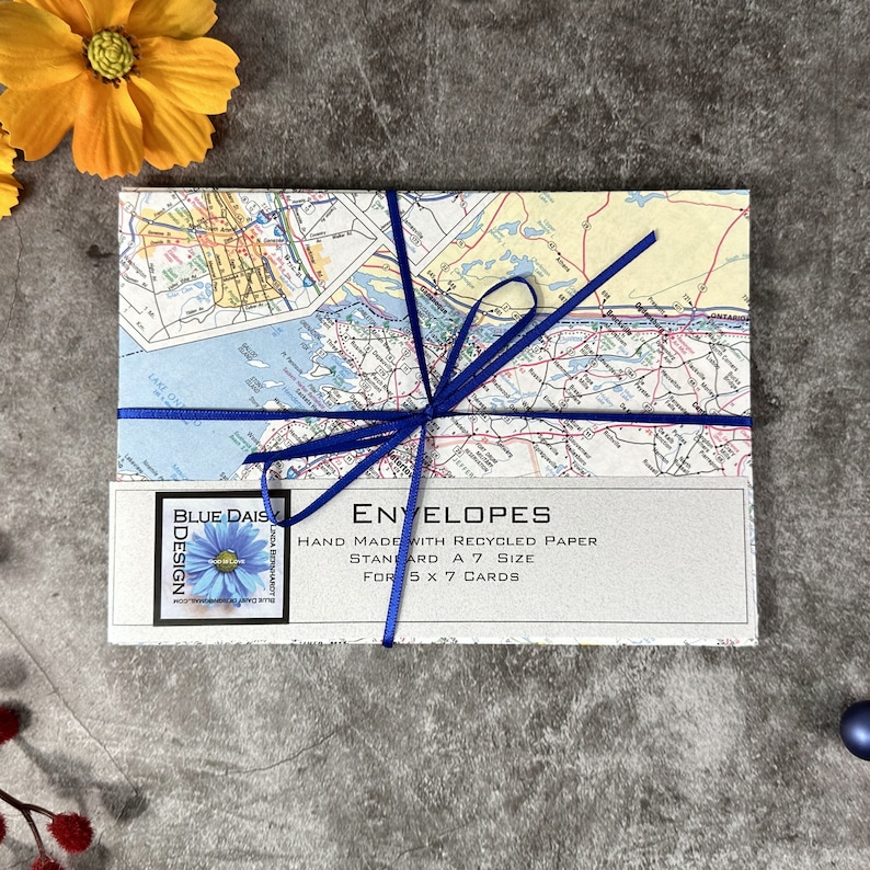 May include: A stack of envelopes made with recycled paper, tied with a blue ribbon. The envelopes are standard A7 size and are for 5 x 7 cards. The envelopes are decorated with a vintage map design.