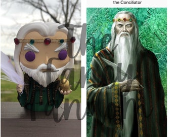Può includere: Una figura Funko Pop di Re Jaehaerys I Targaryen, il Conciliatore, con barba e capelli bianchi, indossa una corona d'oro con gioielli rossi e verdi. La figura tiene in mano una piuma e un globo dorato. Accanto, un ritratto del re.