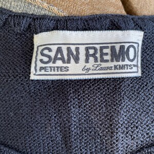 May include: A black label with white text that reads "SAN REMO PETITES by Laura KNITS".