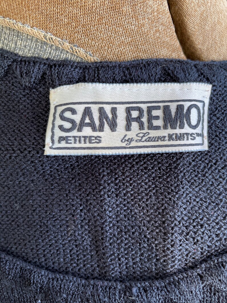 May include: A black label with white text that reads "SAN REMO PETITES by Laura KNITS".