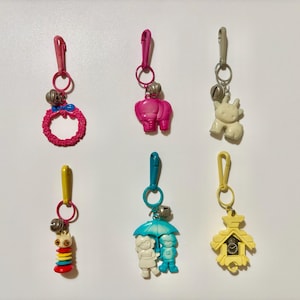 Adornos de plástico retro vintage de los años 80: corona, elefante, vaca, personaje colorido de ojos saltones, amigos para siempre, reloj de cuco amarillo