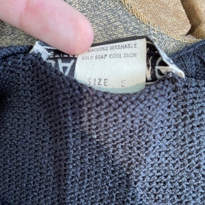 May include: Black and white tag with the text "Machine Washable, Mild Soap, Cool Iron" and "Size S".