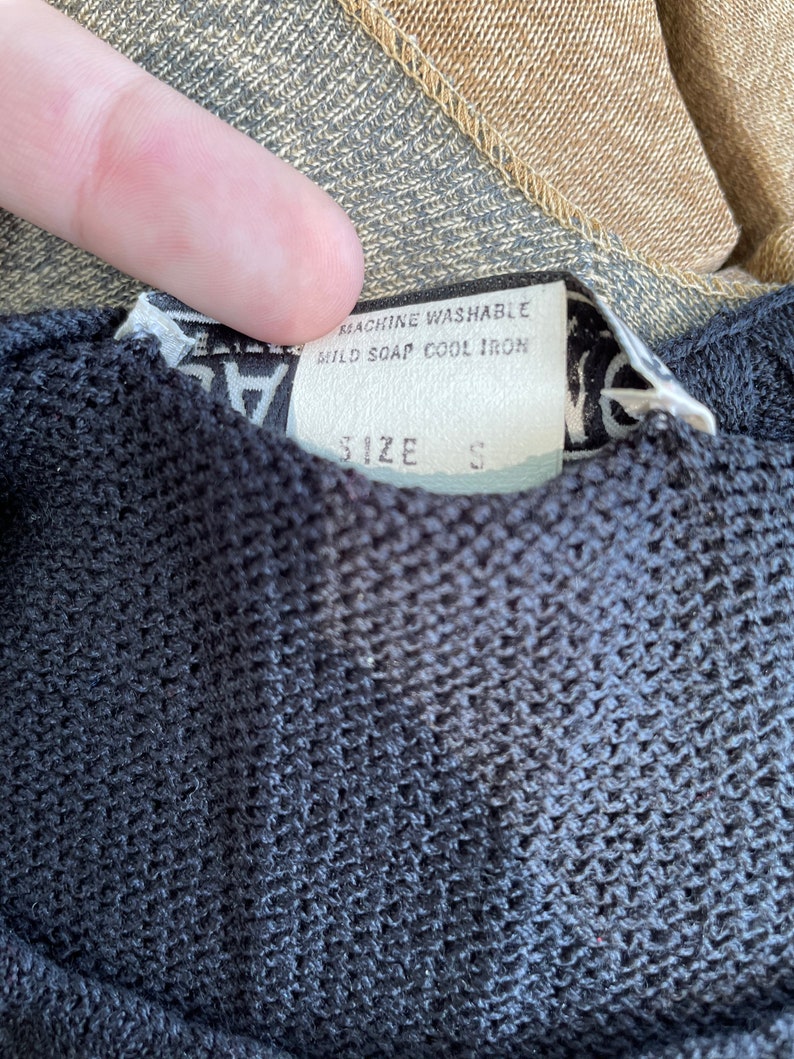 May include: Black and white tag with the text "Machine Washable, Mild Soap, Cool Iron" and "Size S".