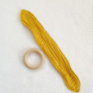 Peut inclure: Un anneau de dentition pour b&eacute;b&eacute; en tissu jaune avec un anneau en bois. Le hochet est fait d'un tissu doux et textur&eacute; et est con&ccedil;u pour &ecirc;tre s&ucirc;r pour les b&eacute;b&eacute;s &agrave; m&acirc;cher.