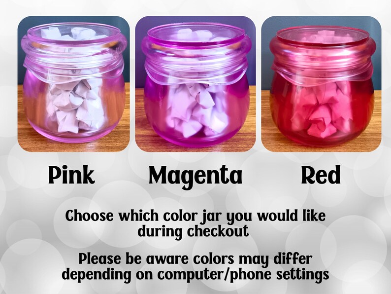 May include: Three glass jars with screw-top lids, each filled with small folded paper stars. The jars are tinted pink, magenta, and red. Text below reads: Pink, Magenta, Red. Choose which color jar you would like during checkout. Please be aware colors may differ depending on computer/phone settings.