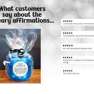 May include: A blue plastic jar wrapped in clear cellophane with a black and white ribbon. The label reads Sweary Affirmation Jar and includes text about daily affirmations. Five star reviews are displayed to the right of the jar.
