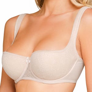 Könnte beinhalten: Beige BH mit zartem Spitzenmuster. Der BH hat breite Träger und eine kleine Schleife in der Mitte. Das Design bietet volle Abdeckung und Halt, ideal für den täglichen Gebrauch.
