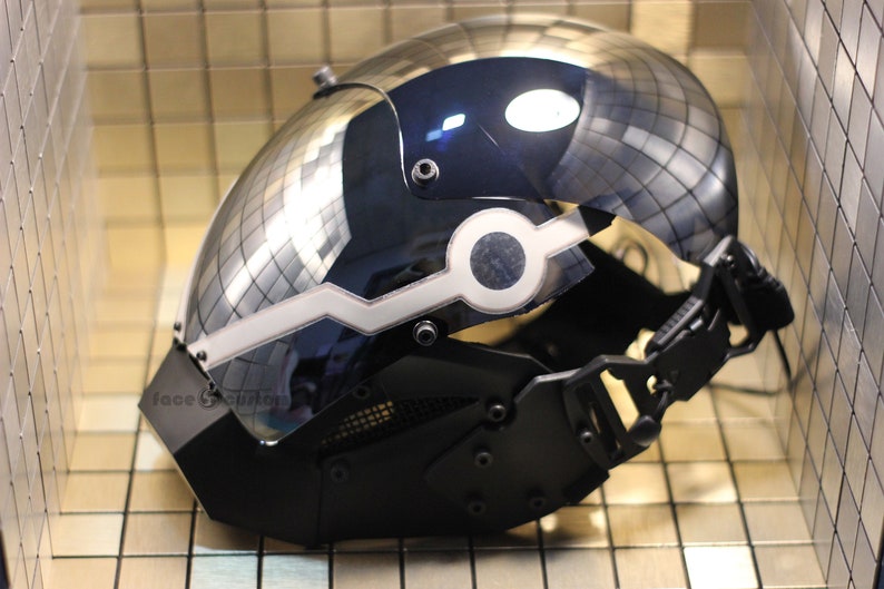 May include: A black and silver helmet with a mirrored visor and a white light strip. The helmet has a black face mask with a mesh grille.