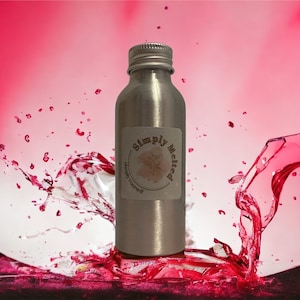 May include: A silver bottle with a white label that says "Simply Melted" and a small tree design. The bottle is surrounded by a pink liquid splash.