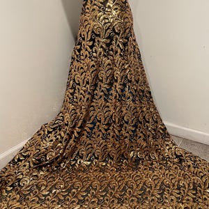 May include: Black mesh fabric with gold sequins in a floral pattern.