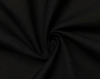 May include: Black fabric with a smooth, slightly textured surface. The fabric is folded and draped, showing its soft and drapey texture.