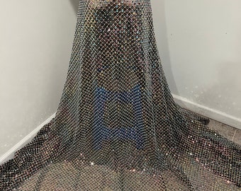 May include: Black mesh fabric with iridescent rhinestones sewn in a grid pattern. The fabric is sheer and has a slight shimmer.