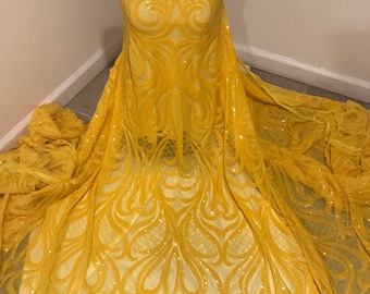 May include: Yellow sequined fabric with a floral pattern. The fabric is draped over a dress form.