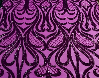 May include: Purple fabric with a black sequined design of swirling patterns. The fabric has a slight sheen.