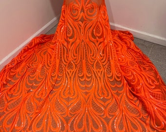 May include: Orange sequined fabric with a paisley design. The fabric is sheer and has a delicate, flowing texture.