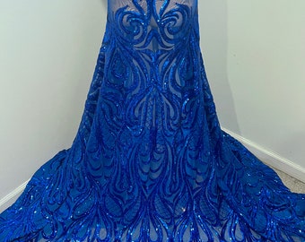May include: Royal blue sequined fabric with a floral pattern. The sequins are scattered throughout the fabric, creating a shimmering effect.