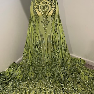May include: Lime green sequined fabric with a floral pattern. The sequins are a darker shade of green and create a raised design.