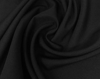 May include: Black fabric with a soft, smooth texture. The fabric is draped and folded, creating a flowing, elegant look.