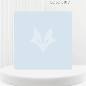 Peut inclure: Un carré bleu clair avec un logo de renard blanc, présenté sur un piédestal blanc. Le texte "COLOR 017" est dans le coin supérieur droit. Le fond est un rideau blanc.