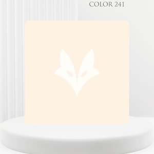 Op de afbeelding: Een vierkant product in licht perzikkleur met een wit vossenkoplogo. De tekst "COLOR 241" staat boven het product. Het wordt gepresenteerd op een witte, ronde sokkel tegen een witte achtergrond.