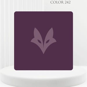 Op de afbeelding: Een vierkante, donkerpaarse afbeelding met een lichtpaars vossenkoplogo. De tekst "COLOR 242" staat boven de afbeelding. De afbeelding wordt weergegeven op een witte, ronde sokkel.