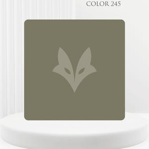 Peut inclure: Un carreau carré vert olive présentant une silhouette de tête de renard vert olive plus clair centrée. Le texte COLOR 245 est imprimé dans une police sombre au-dessus du carré. Le design est plat, affichant un bloc de couleur uni.