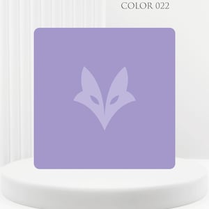 Peut inclure: Un carreau carré de couleur lavande présentant un motif central plus clair en forme de tête de renard stylisée. Le texte COLOR 022 est imprimé dans le coin supérieur droit. Le carreau possède des coins arrondis et une finition mate.