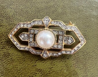broche de metal con diamantes y perlas artificiales