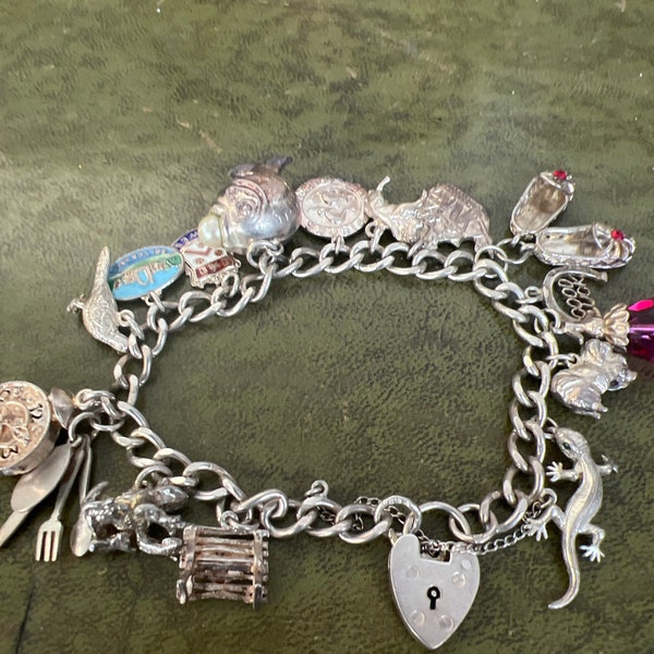 Impresionante pulsera de dijes de plata maciza de 1950 con 14 dijes