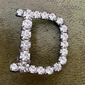 broche vintage con diamantes de imitación en forma de letra D