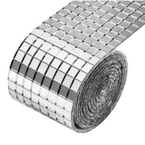 May include: A roll of reflective, silver mosaic tiles. The tiles are small, square, and arranged in a grid pattern. The roll is partially unraveled, revealing the individual tiles and their reflective surfaces. The overall effect is a shimmering, decorative material.