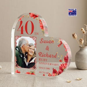 May include: A heart-shaped acrylic photo frame with a picture of a couple kissing. The frame has red floral accents and text that reads "40th Ruby Anniversary" and "Susan & Richard". Made in Australia.
