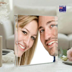 May include: A clear acrylic photo block showing a smiling couple. The block displays a close-up of the faces of a man and a woman. The product has a "Made in Australia" sticker.