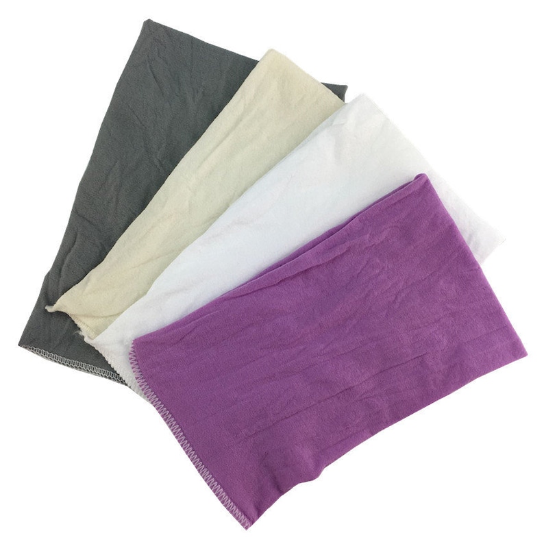 Puede incluir: Cuatro pa&ntilde;os de tela en diferentes colores: gris, beige, blanco y morado. Los pa&ntilde;os est&aacute;n doblados y apilados uno encima del otro.