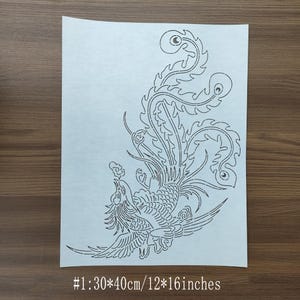 Può includere: Uno stencil di carta bianca con un design dettagliato di un'uccello fenice con le ali spiegate. Lo stencil misura 30 cm per 40 cm, o 12 pollici per 16 pollici.