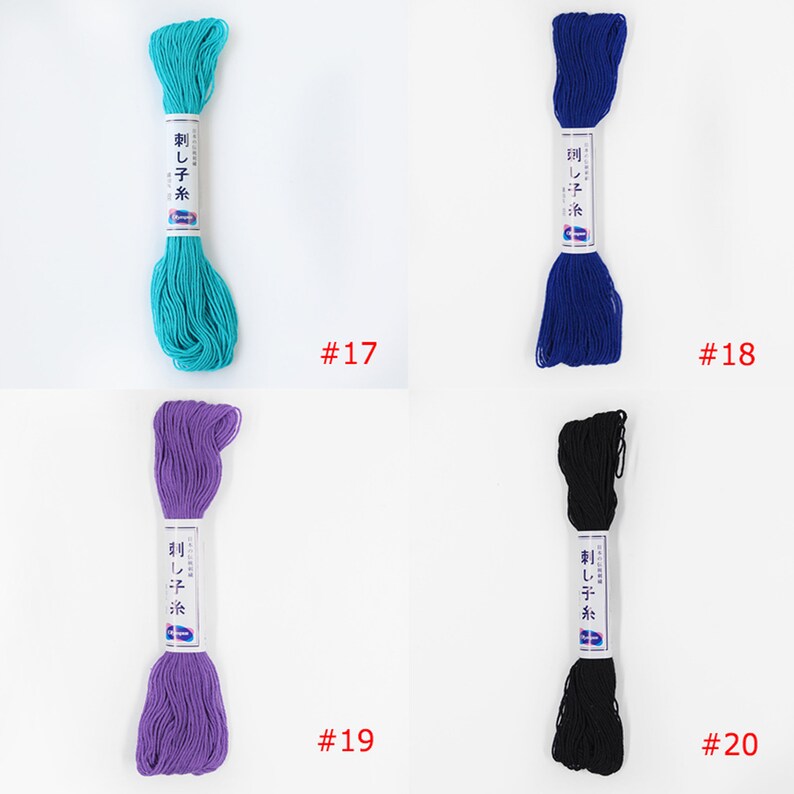 May include: Four spools of embroidery floss in different colours: turquoise, blue, purple, and black. Each spool has a white label with Japanese text and the words "Sashiko Ito" printed on it. The spools are numbered 17, 18, 19, and 20.
