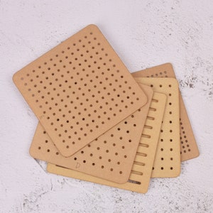 May include: Four wooden pegboards of different sizes and patterns. The pegboards are stacked on top of each other. The largest pegboard has a grid pattern of holes, while the other pegboards have different patterns of holes and lines.