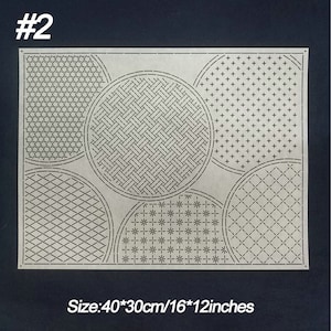 May include: A beige fabric embroidery pattern with five different circular designs. The designs include a star pattern, a woven pattern, a plus sign pattern, a diamond pattern, and a flower pattern. The fabric is 40cm by 30cm or 16 inches by 12 inches.