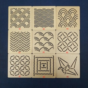 May include: Nine wooden squares with different geometric patterns cut out. The squares are numbered 1 through 9.