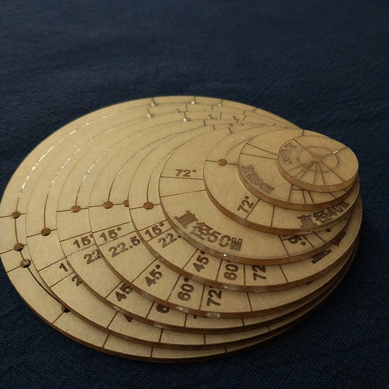 May include: A set of nine circular wooden rulers with markings in degrees and inches. The rulers are nested inside each other, creating a spiral pattern.