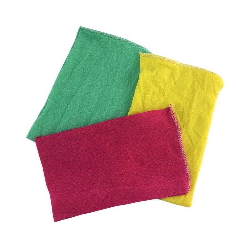Puede incluir: Tres pa&ntilde;os de diferentes colores: verde, rojo y amarillo. Los pa&ntilde;os est&aacute;n doblados y apilados uno encima del otro.
