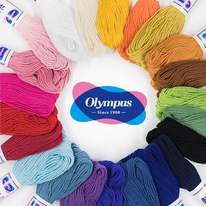 May include: A variety of colours of Olympus embroidery floss, arranged in a circle. The floss is wound around spools and the brand name "Olympus - Since 1908" is in the centre of the circle.