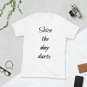 Puede incluir: Camiseta blanca con texto negro que dice "Seize the day darts".